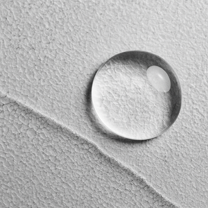 close-up of a clear serum droplet from a silicone-free luxury hair oil, showing lightweight nourishing texture